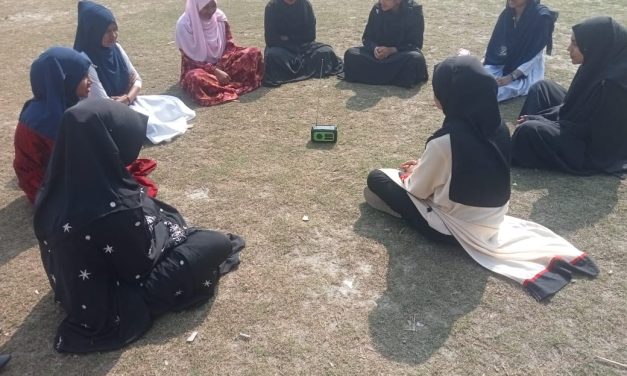 খোলা মাঠে রোদে বসে রেডিও মেঘনা শুনছেন পদ্ম ক্লাবের সদস্যরা